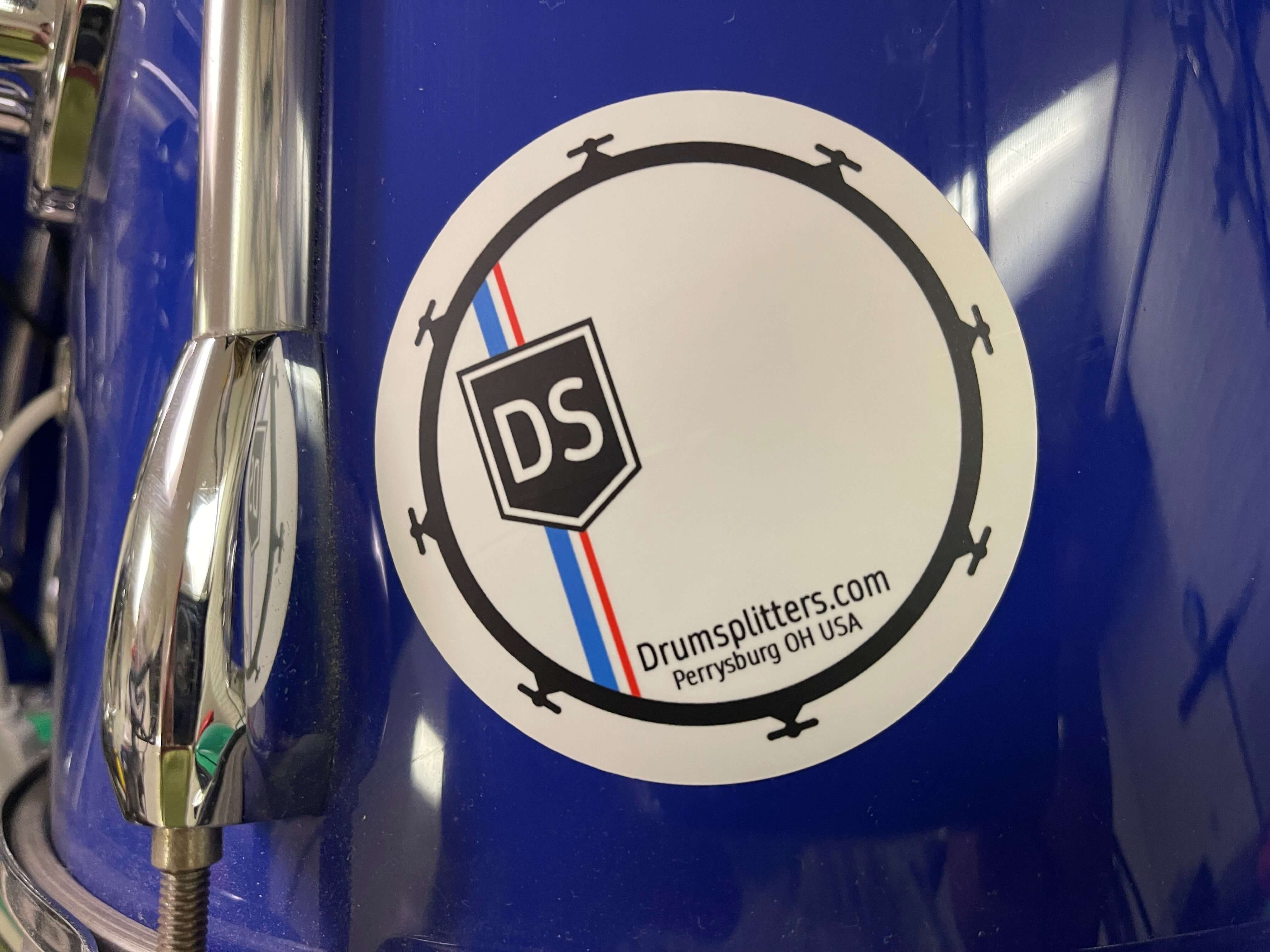 Drumsplitter sticker on a blue drum, featuring a matte finish and cool design for drumming enthusiasts.